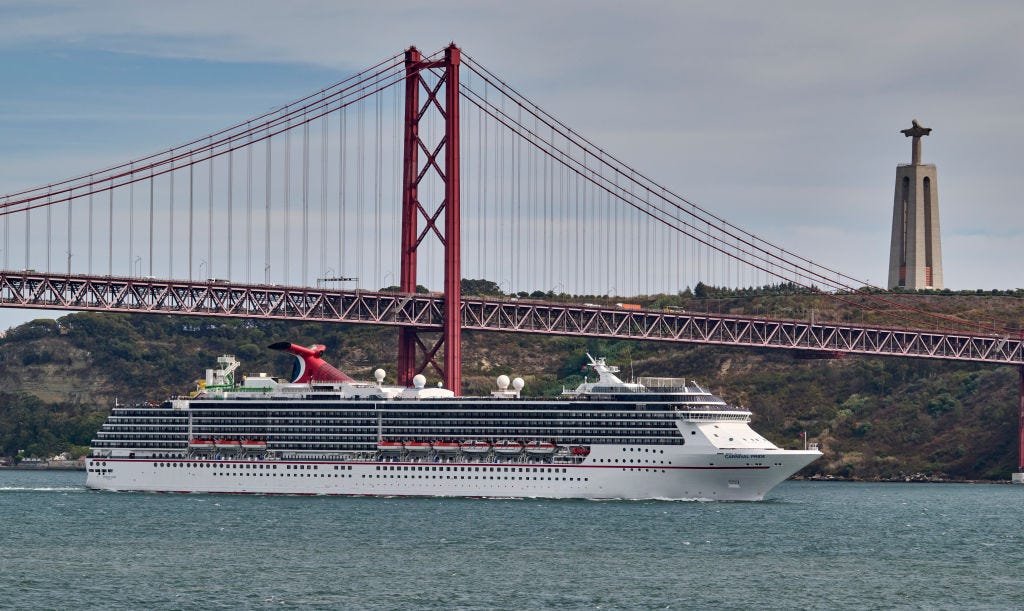 A Carnival cruise ship with the Golden Gate Bridge in background