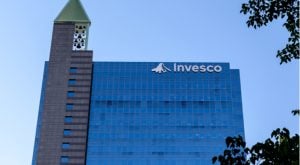 The logo for Invesco Ltd (IVZ) is displayed on a tall office building front.